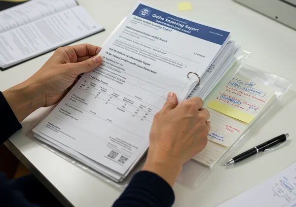 Parent organizing ADHD screening report and child documents